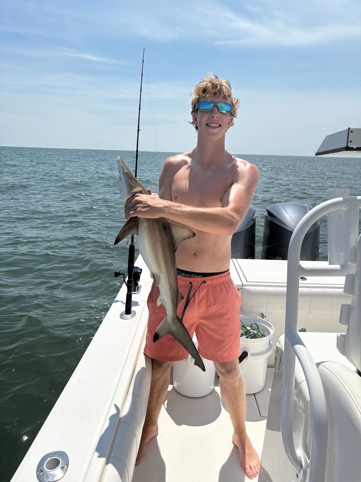 A young angler holding a shark on a Hilton Head shark fishing charter